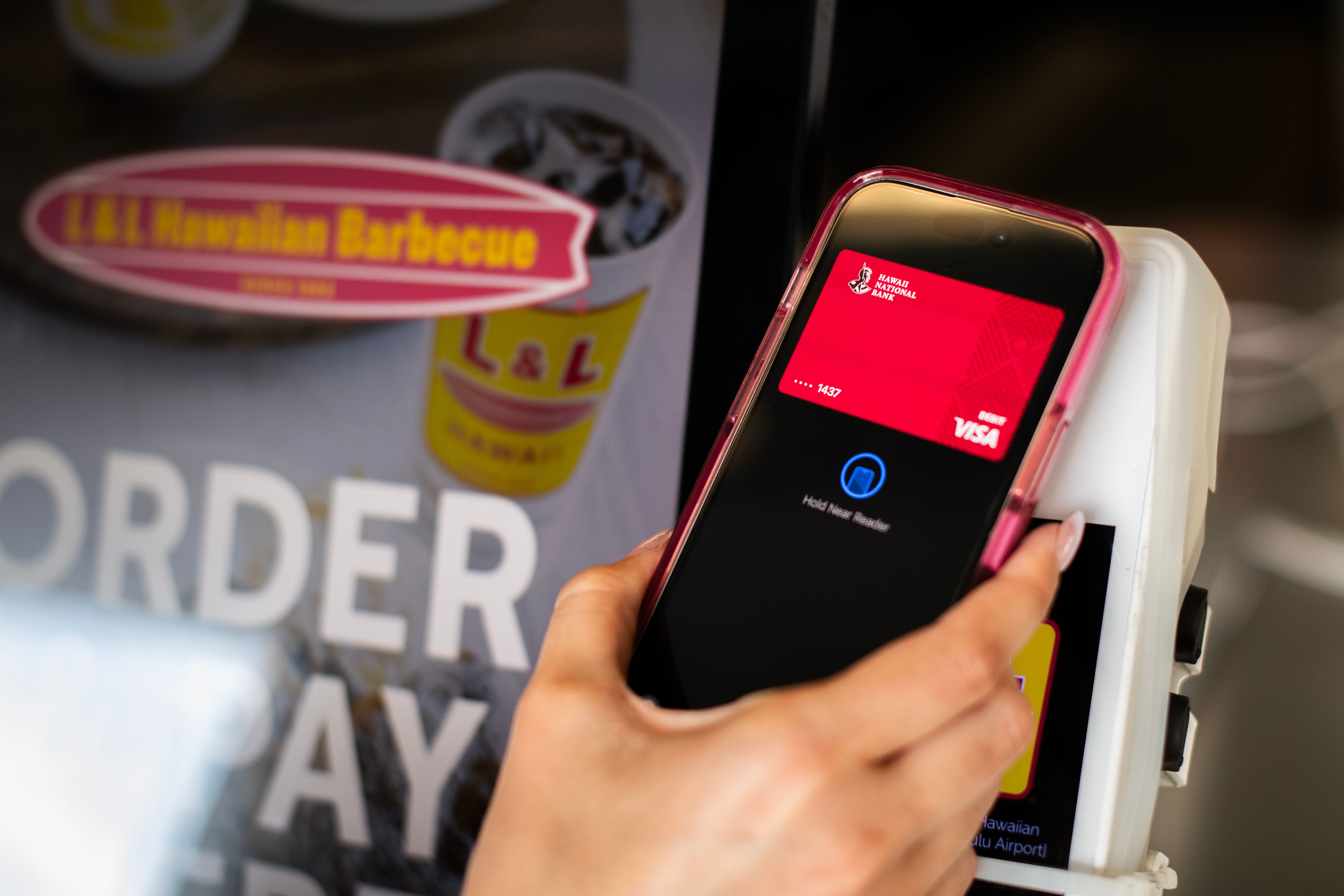 Hand holding phone over a card reader
