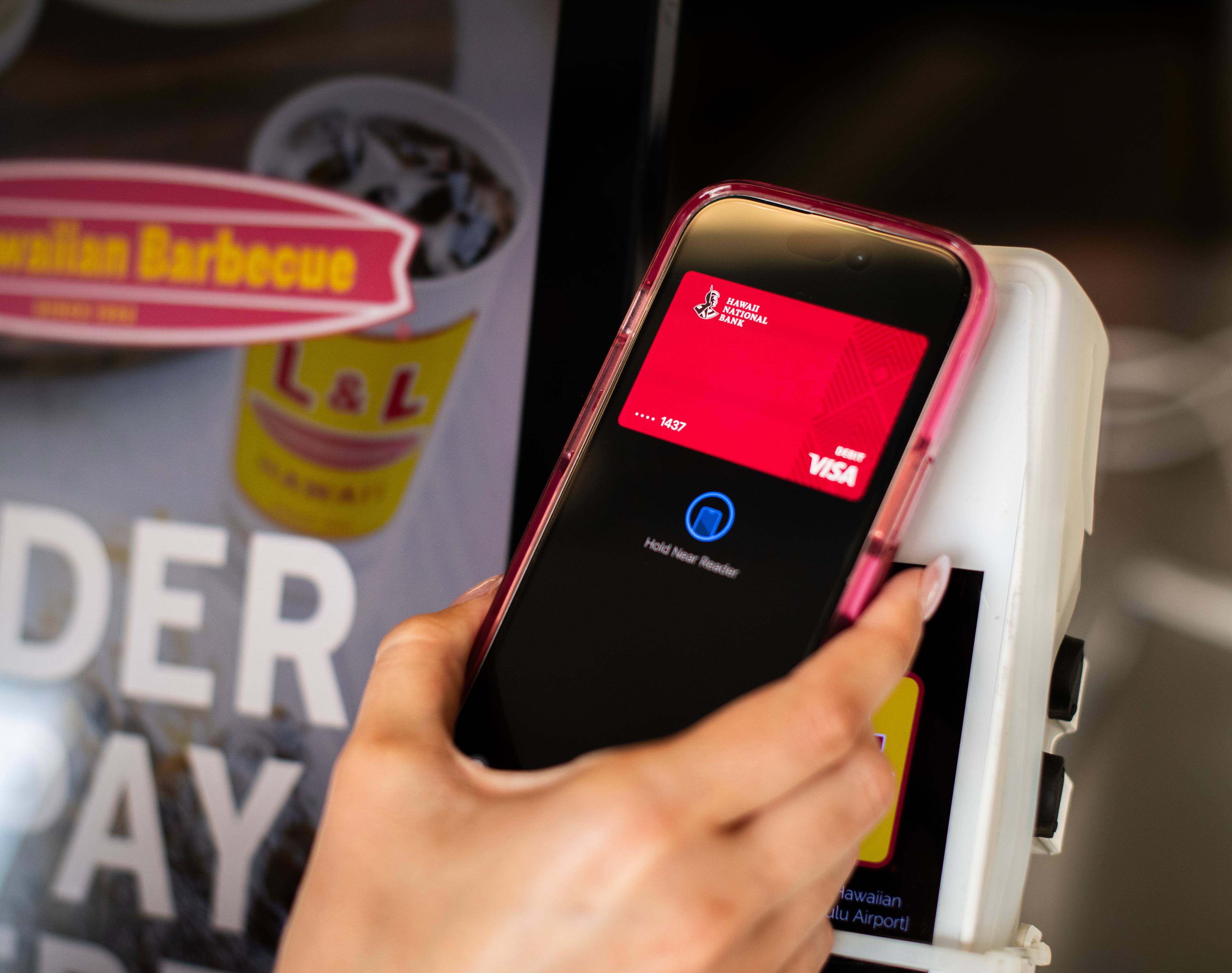 Hand holding phone over a card reader