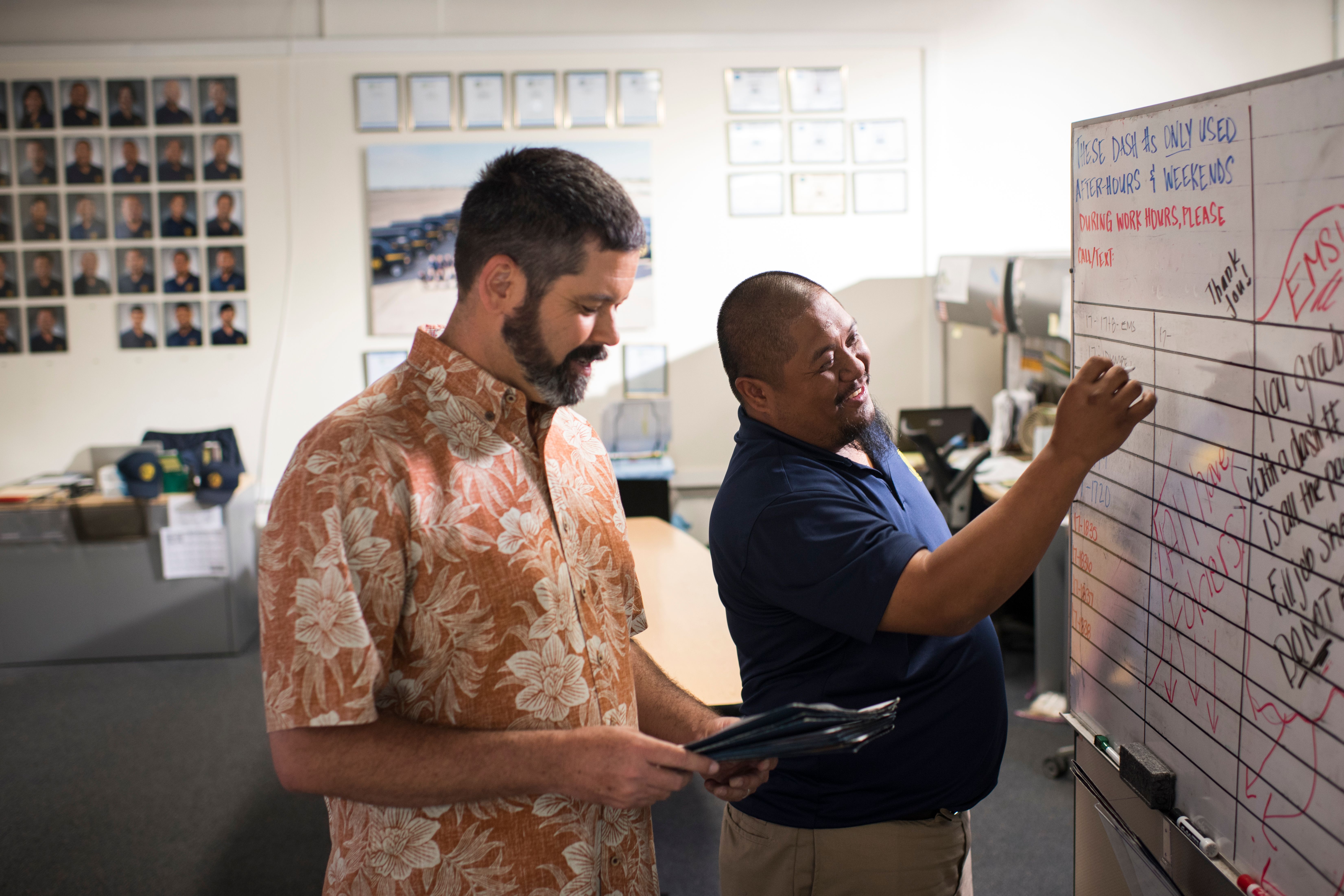 Video cover image shows business owner Mark Harris looking at a folder next to a male employee writing on a white board.