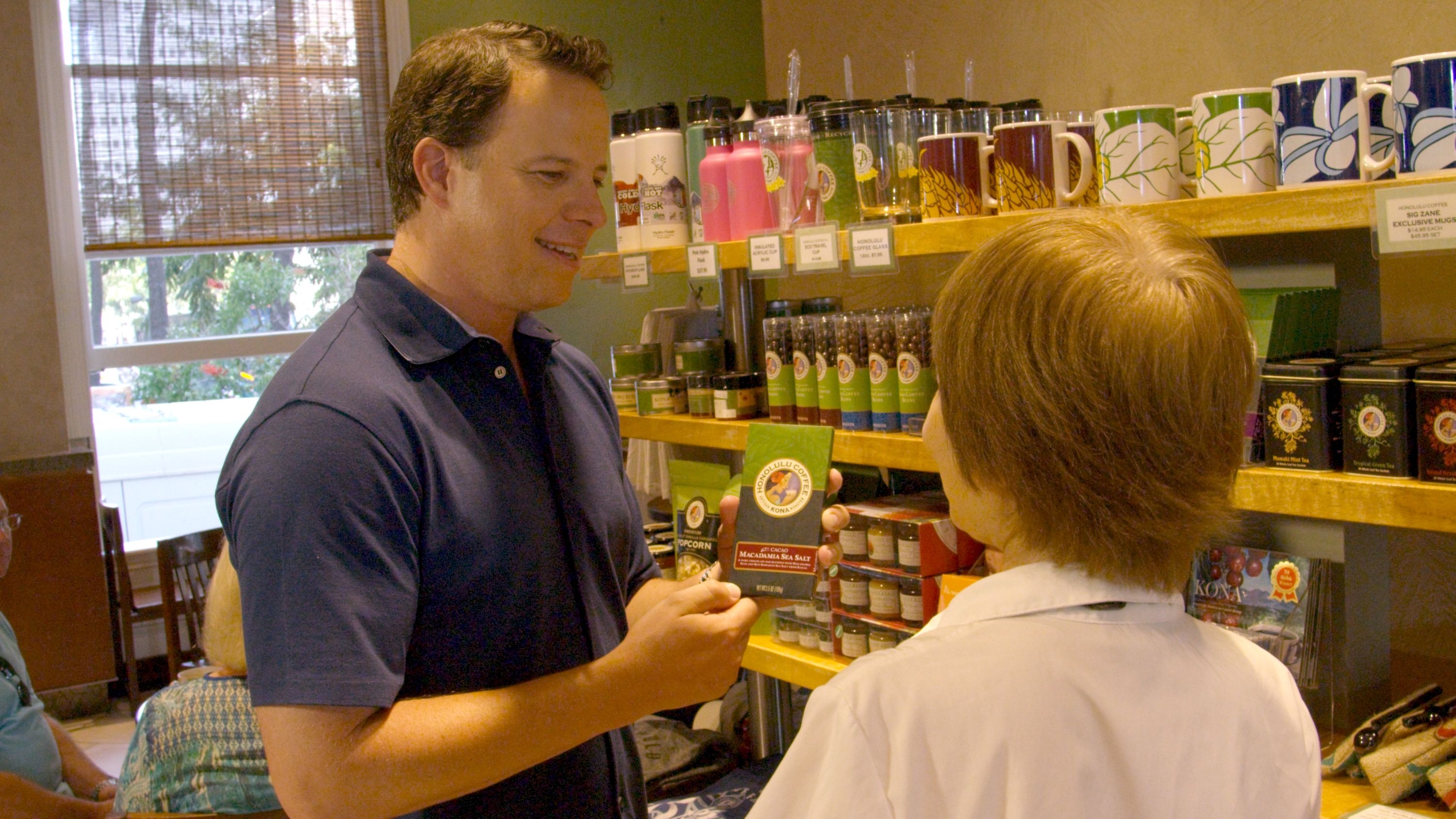Video cover image shows Entrepreneur Ed Schultz showing a coffee package to a customer