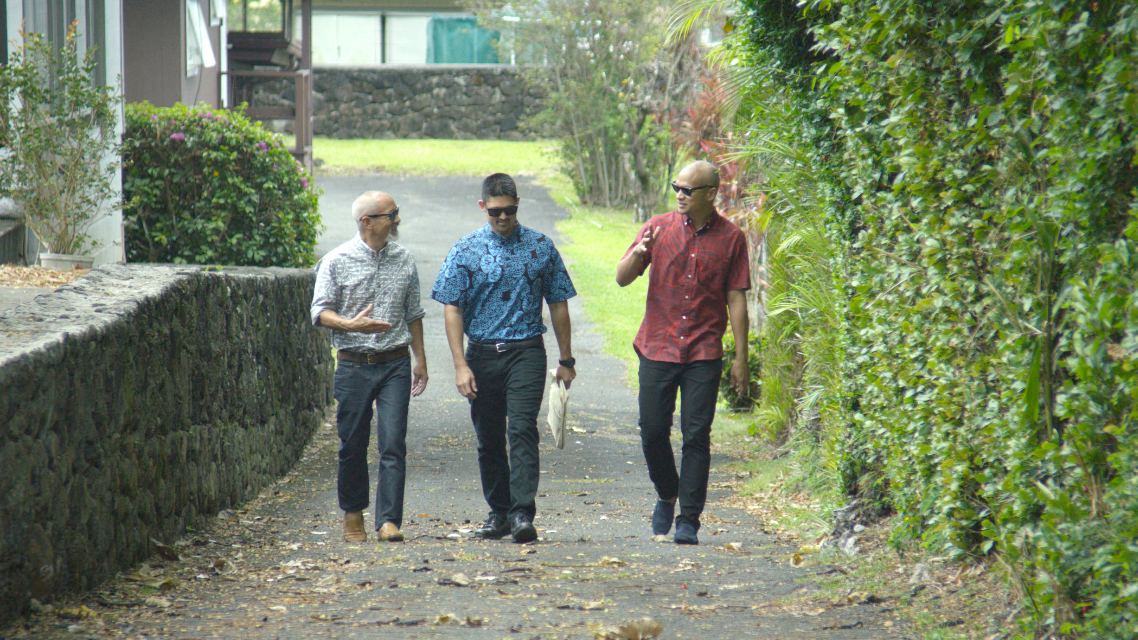 Sig and Kuhao Zane walking on a path toward the camera on either side of their banker