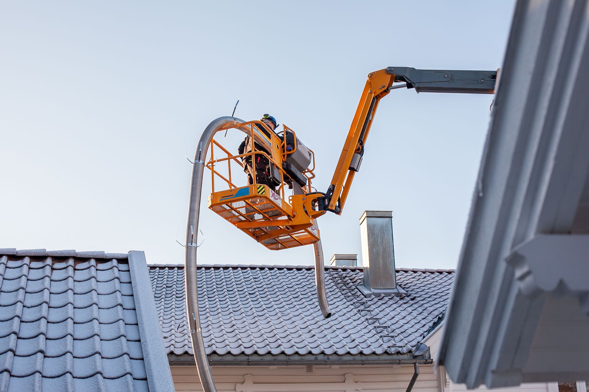 Arbeid på skorstein under rehabilitering av pipe på bolig