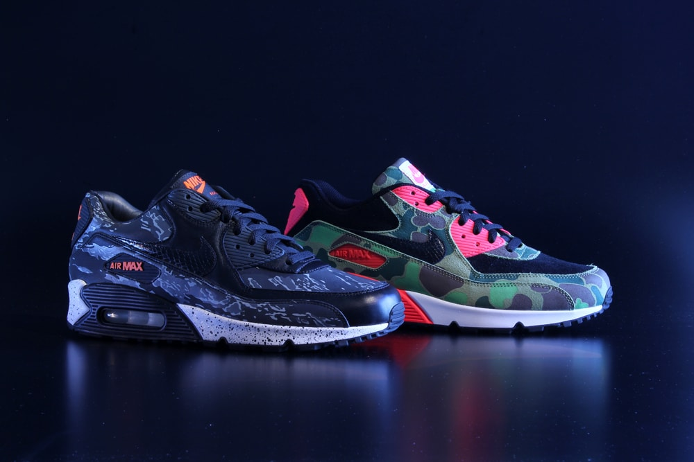 Two colourful camo Nike Air Max sneakers on black reflective surface