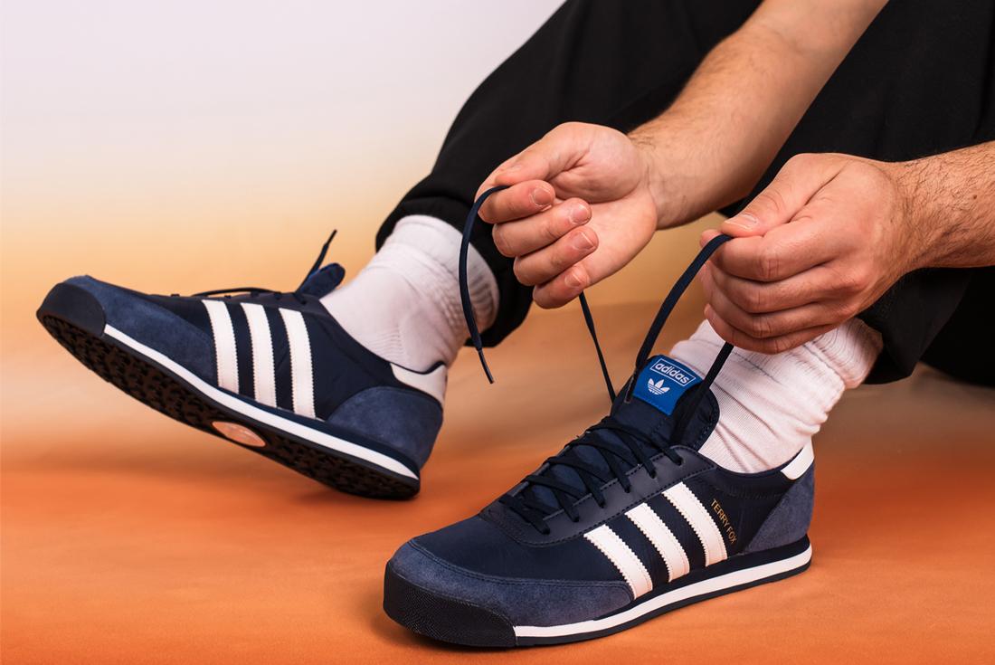 terry fox adidas orion on foot blue with orange background