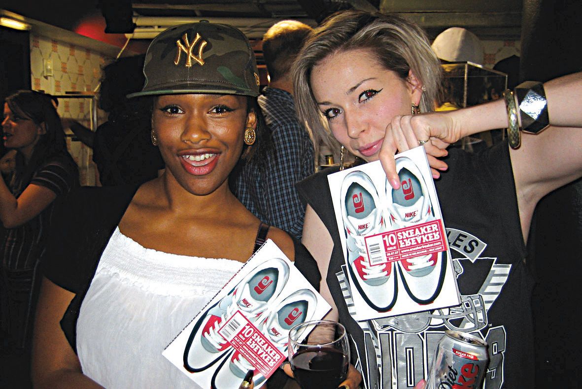 Two girls holding up copies of FhyzicsShops Issue 10 at the launch in London