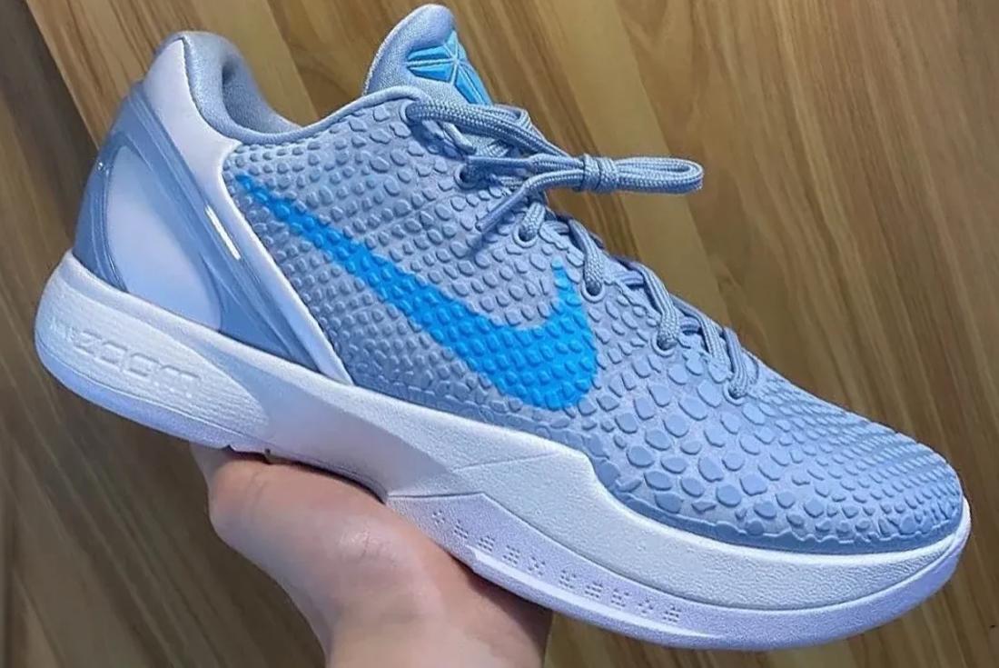 Blue Nike Kobe 6 sneaker held in person's hand