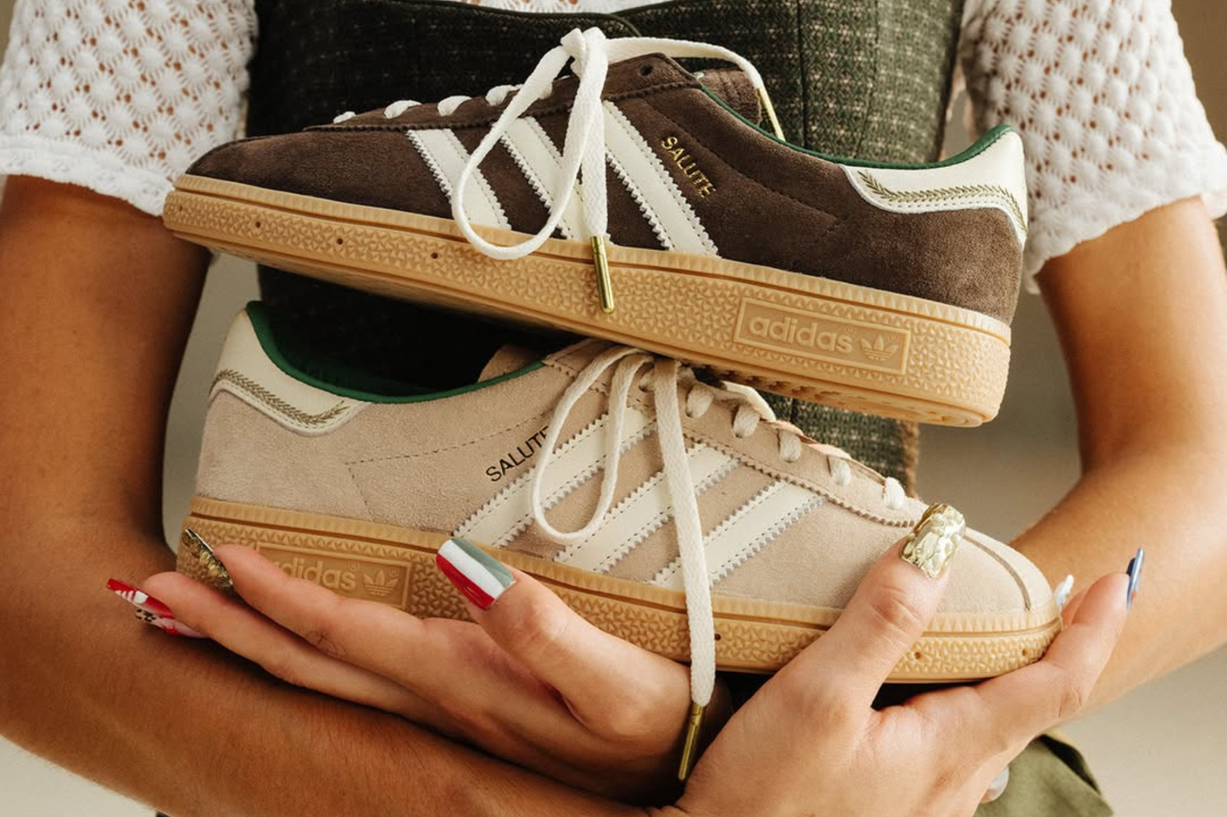 a pair of hands holding adidas sneakers with italy flag printed nails