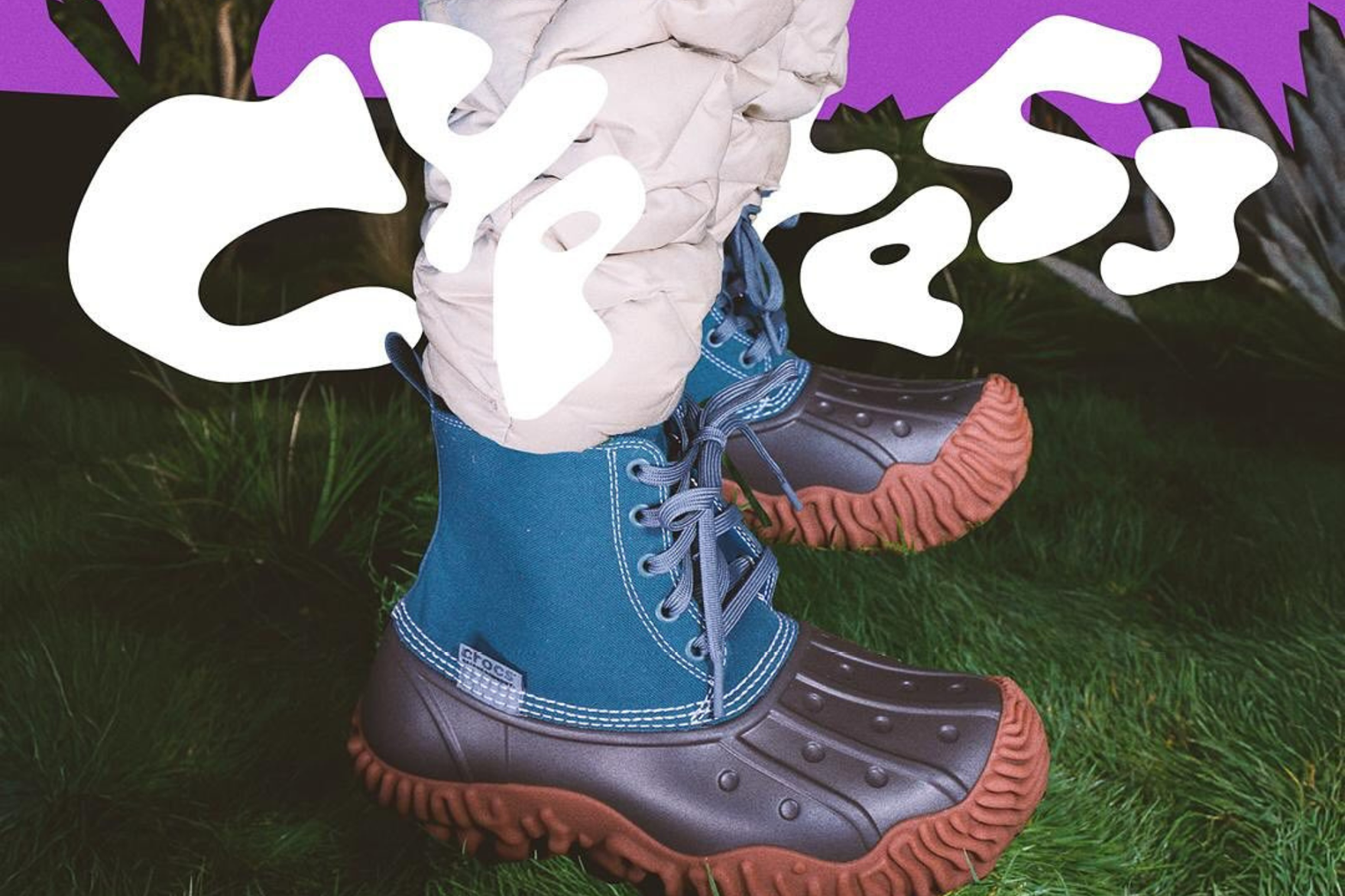 a crocs-style lace-up boot in blue, purple and red on some grass