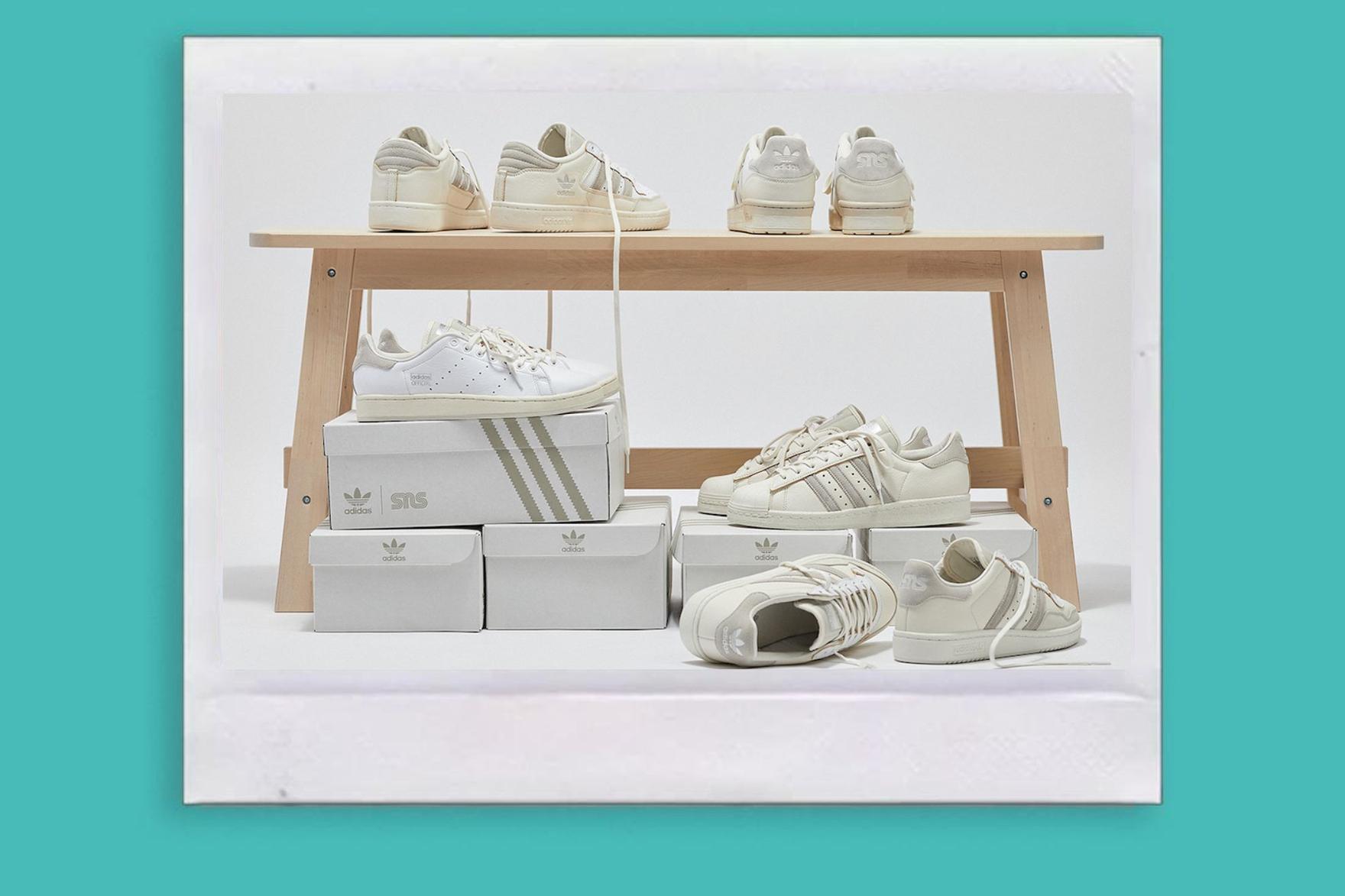 Several pairs of bright white sneakers resting on shoeboxes
