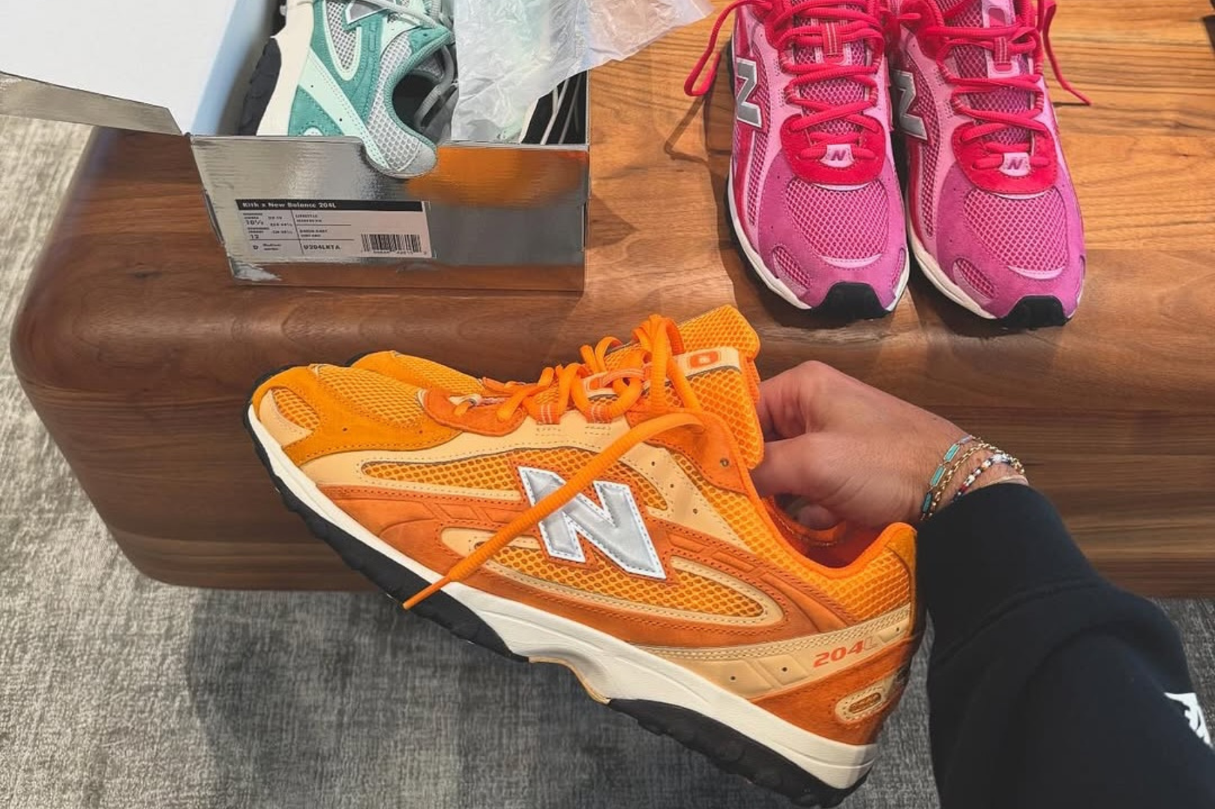 three sneakers: a green, orange, and pink all by new balance