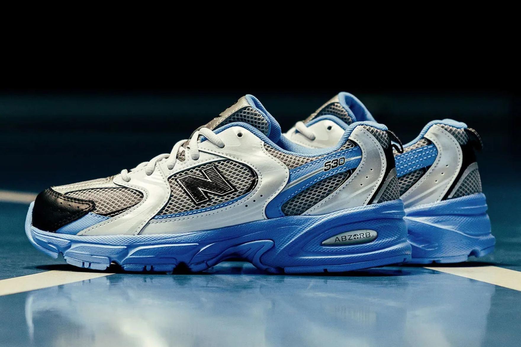 Blue silver and black New Balance sneakers on reflective surface