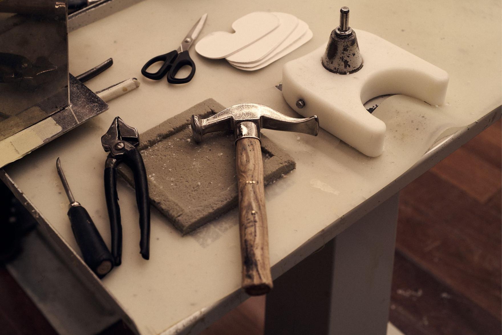 Close-up of a shoe-maker's workbench with tools and scissors