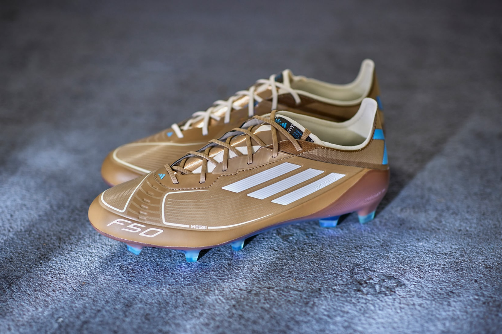 brown f50 football boots on a blue carpet