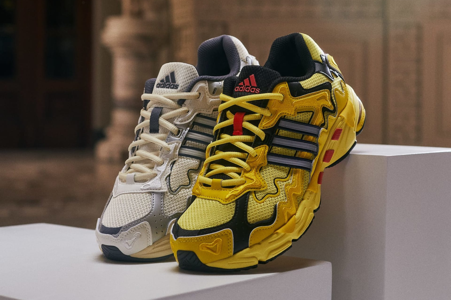 yellow and white adidas cl sneakers sitting on a plinth