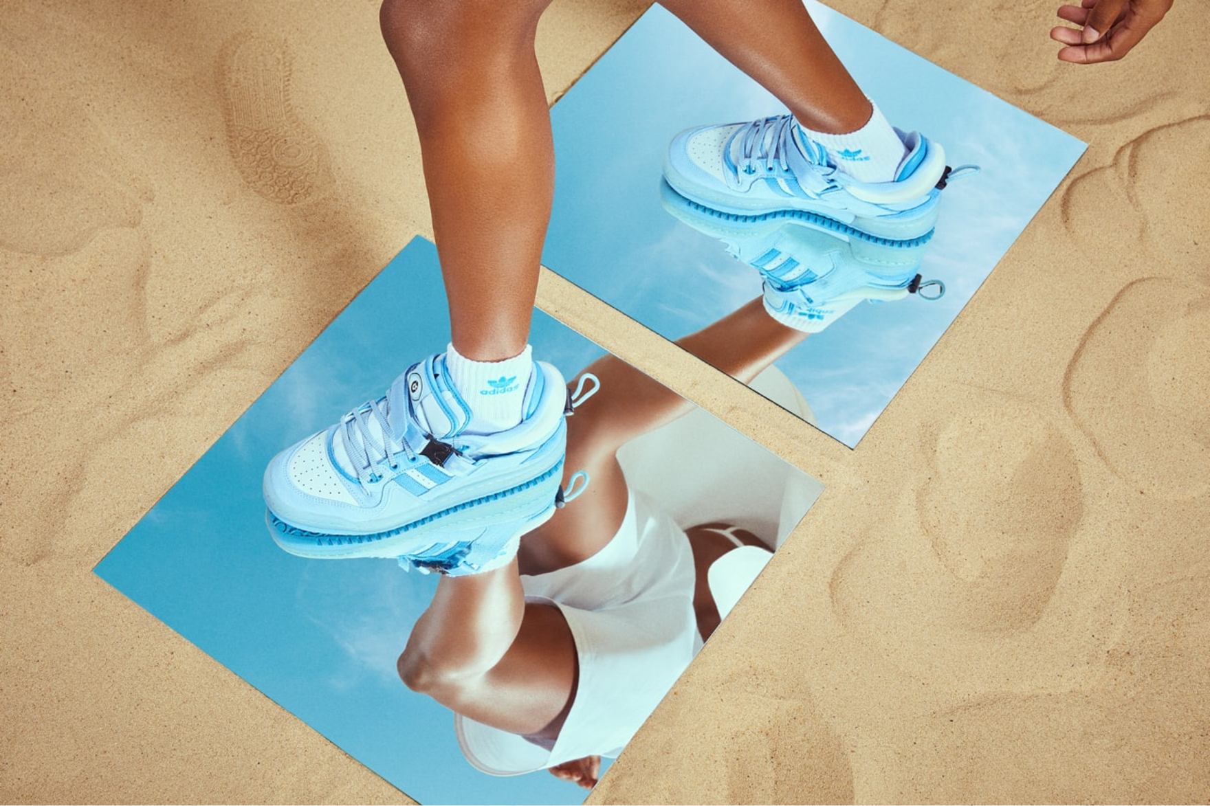 Blue adidas sneakers on-foot standing on a mirrored surface