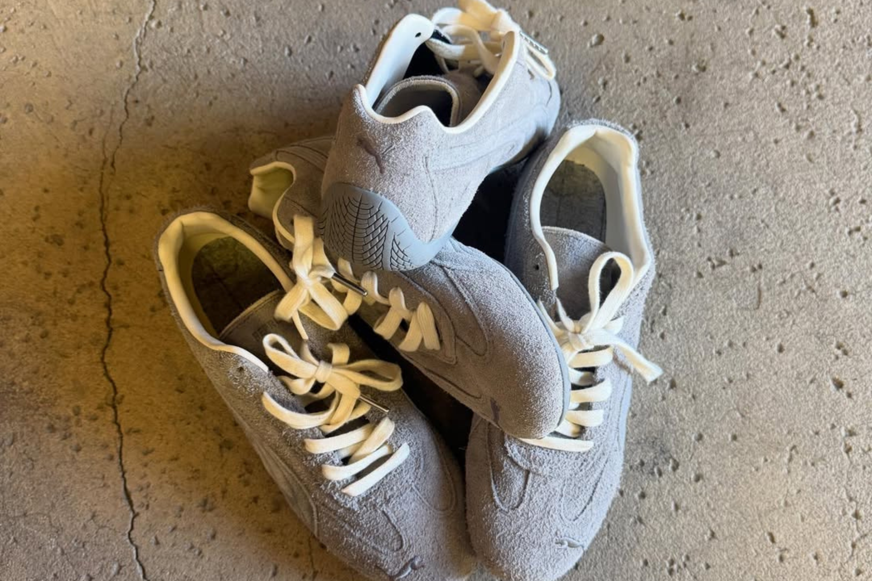 stacked pile of puma speecats in grey on concrete floor