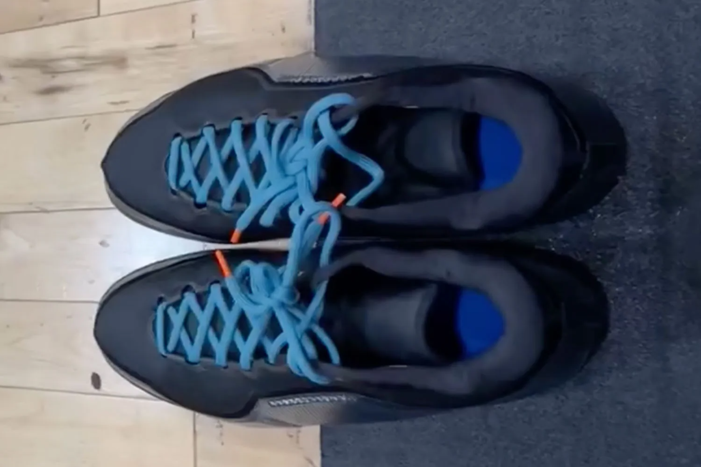 a pair of blue and black nike sneakers with blue laces