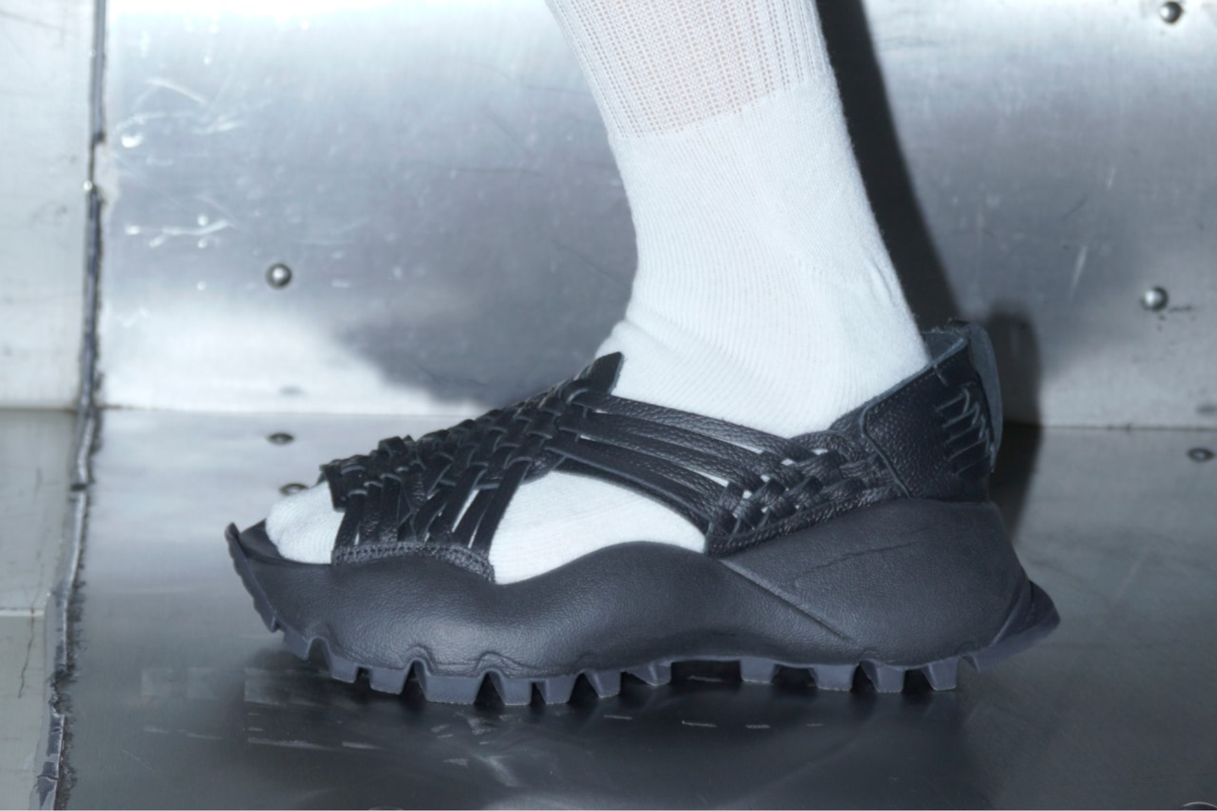 a close up shot of the willy chavarria sandal worn with a white sock