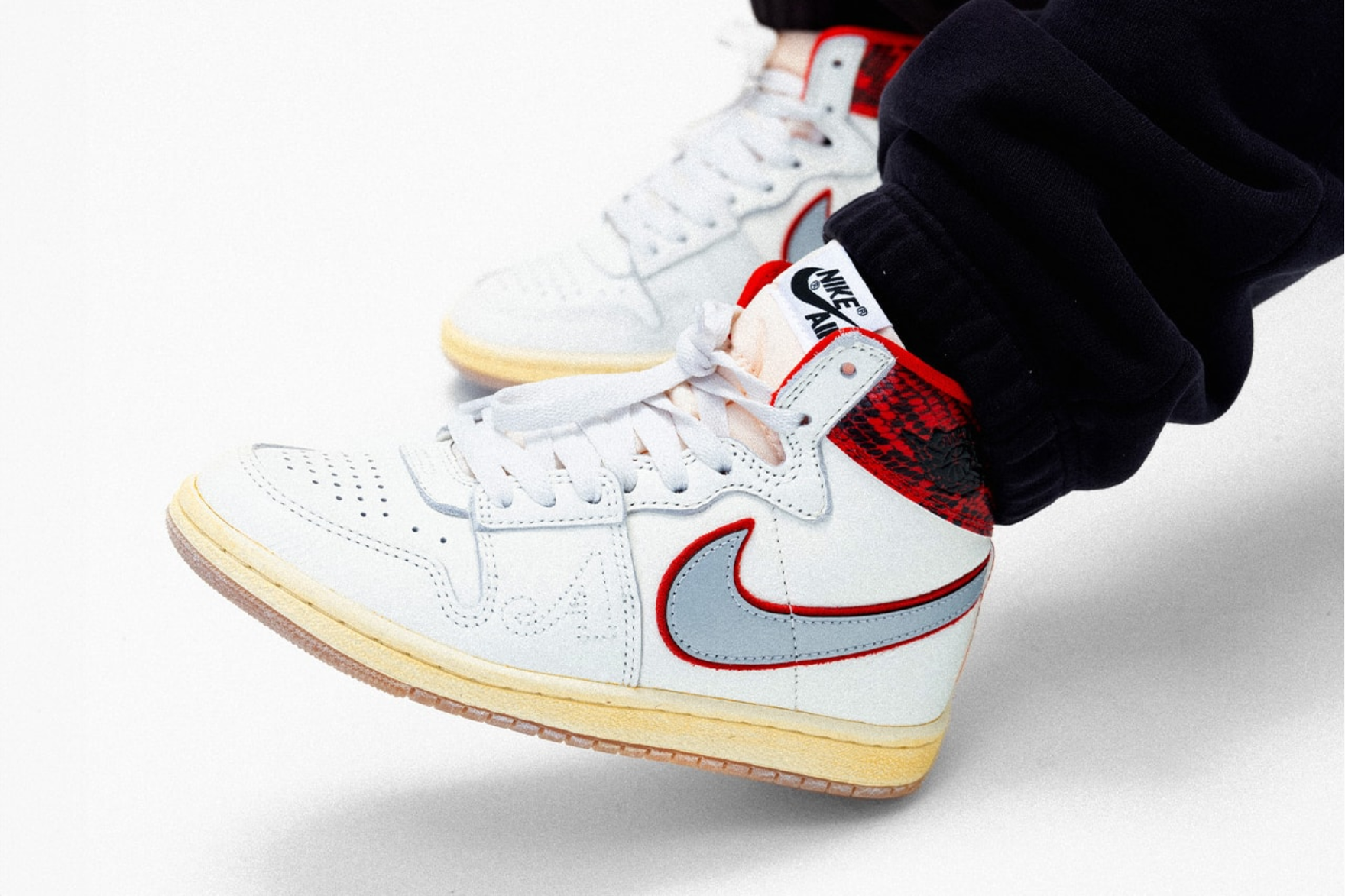 black and red air jordan on foot shot with red collar and yellow sole