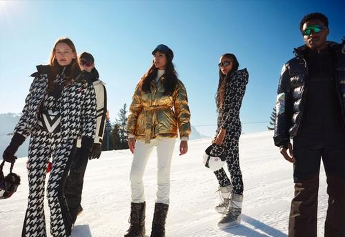 Group of people standing on snowy mountain wearing Perfect Moment skiwear