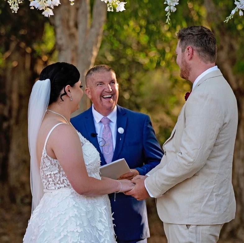 Mark laughing with a couple as they exchange vows