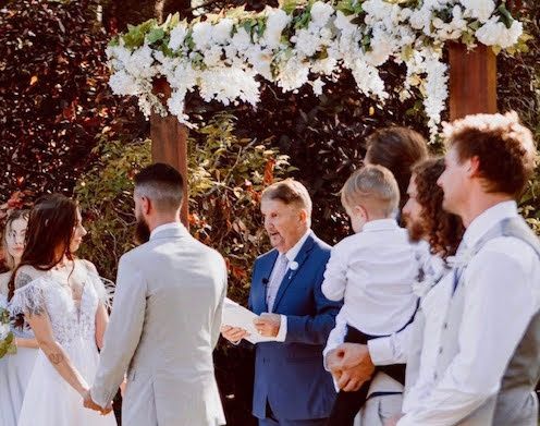 Mark conducting a ceremony surrounded by family and guests