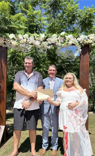 Mark with a couple and child holding a commemorative marriage certificate
