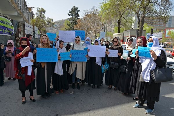 a group of Afghan women holding signs of protest