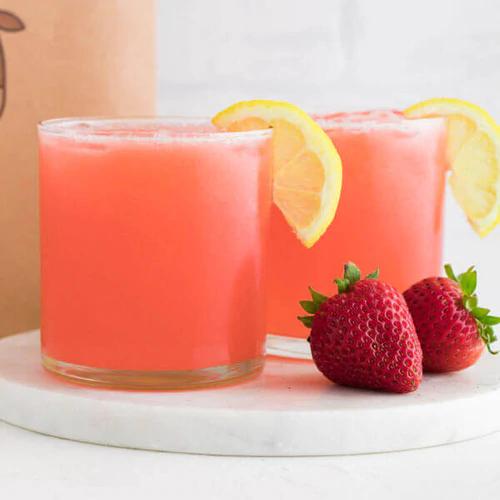 Freshly made Strawberry Lemonade in an Almond Cow machine, garnished with a slice of lemon