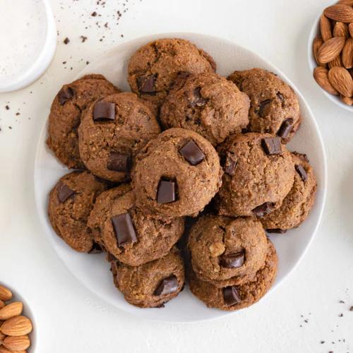 Freshly baked almond pulp chocolate chip cookies on a white plate