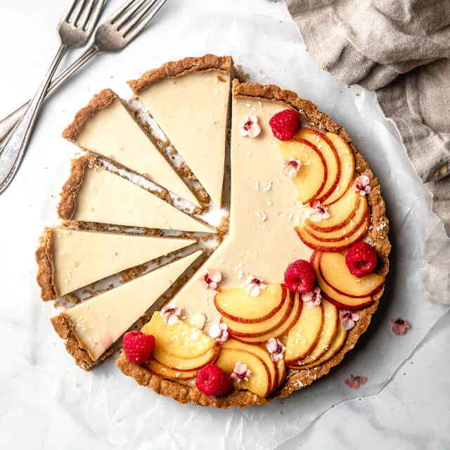 Gluten-free and dairy-free Peach Tart topped with fresh peaches from Almond Cow