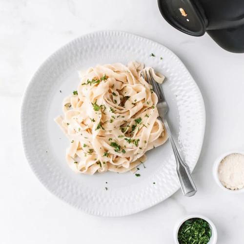 Vegan Alfredo Pasta made from cashew pulp served on a white plate