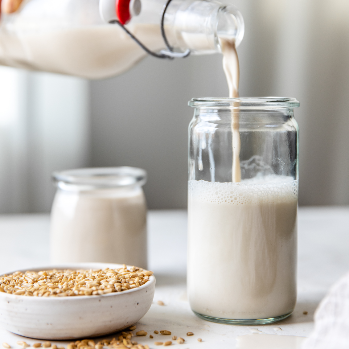 Creamy Pro Oat Milk from Almond Cow being poured into a glass cup