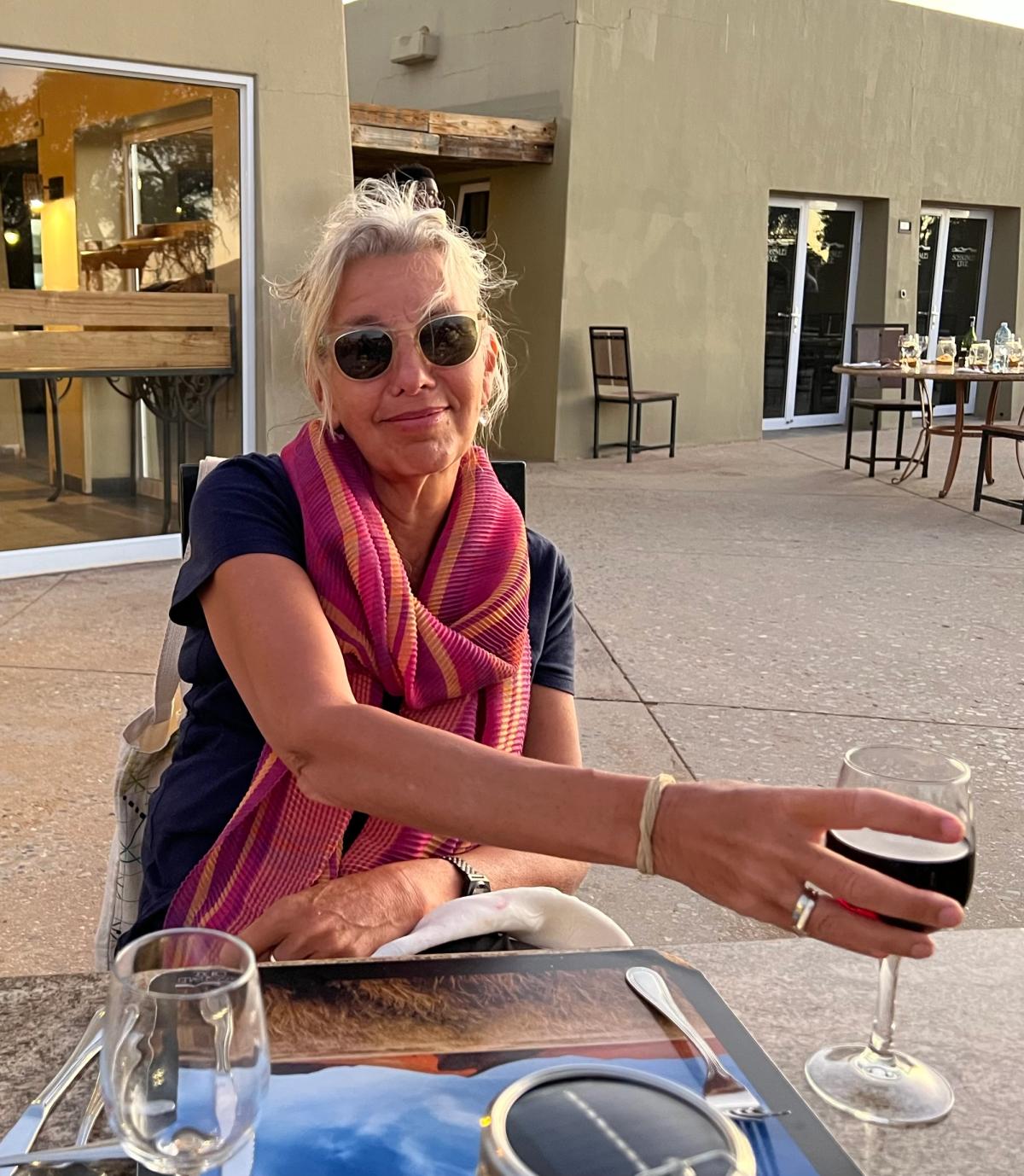 woman in sunglasses having wine early evening