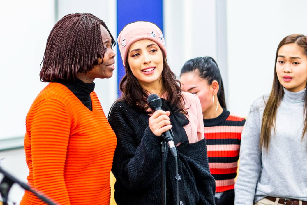 Mennesker med ulik etnisk tilhørighet synger sammen.
