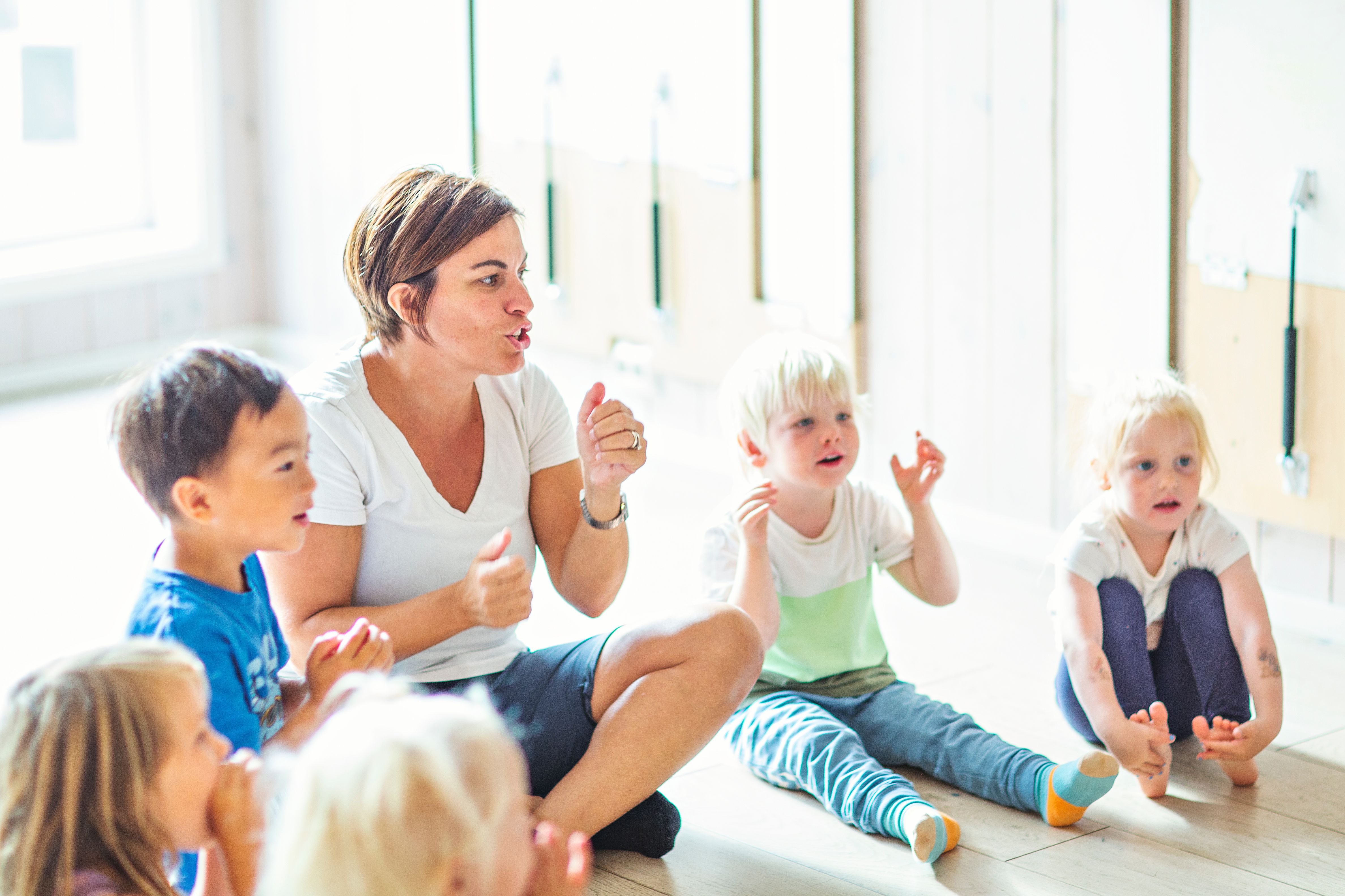 Barn i en Syngende barnehage som synger sammen med en ansatt.