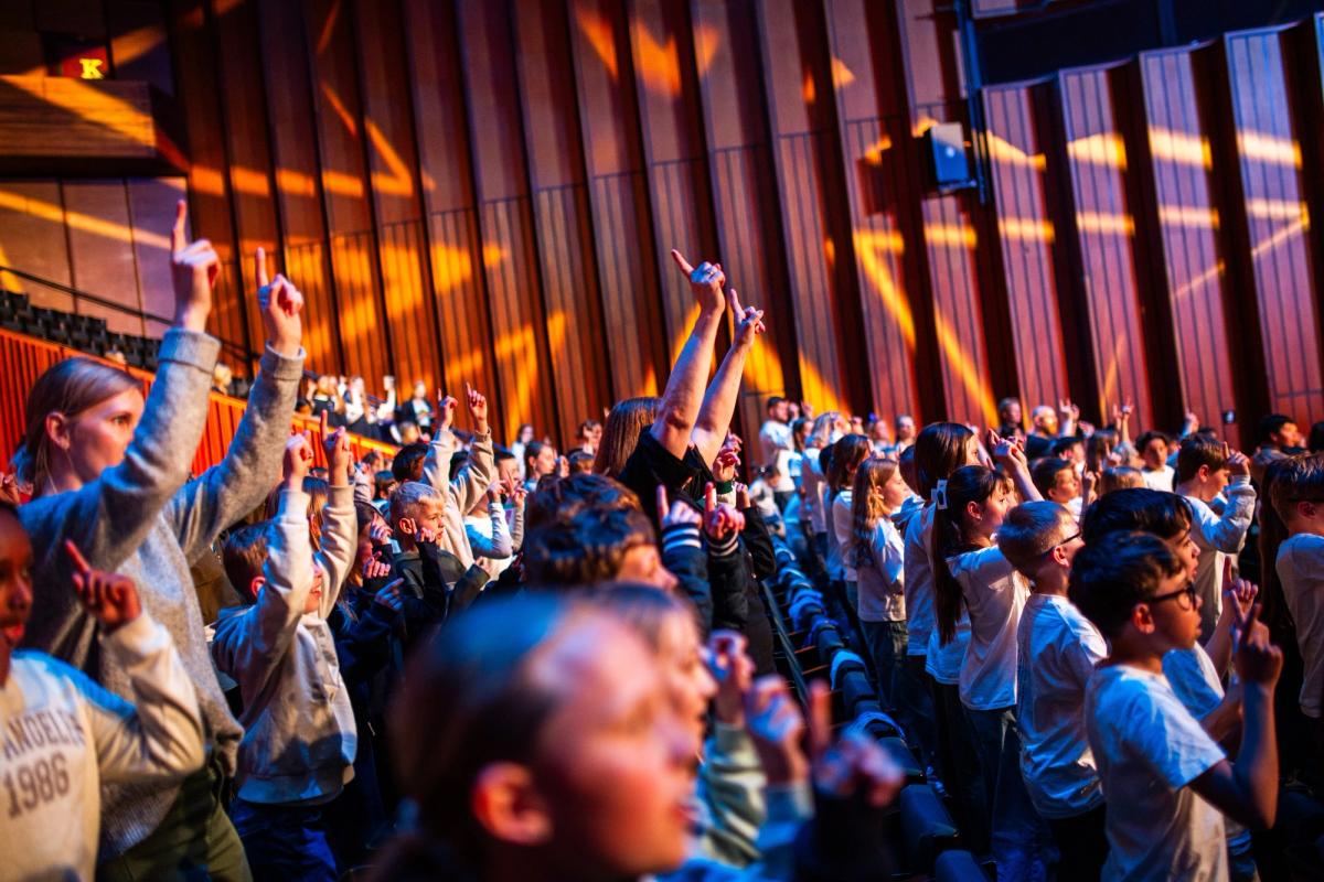 Elever og lærere synger sammen i Oslo konserthus.