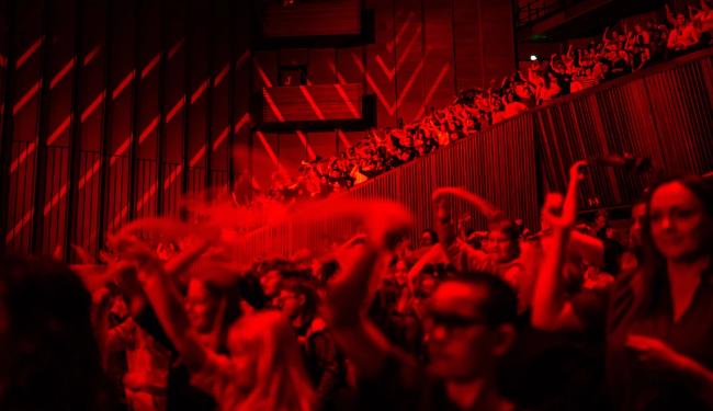 Elever synger og danser sammen i Oslo konserthus.