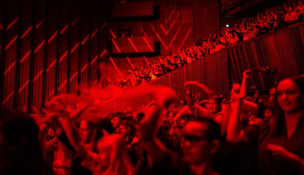 Elever synger og danser sammen i Oslo konserthus.