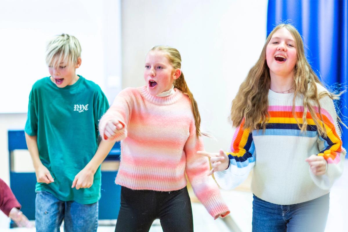 Elever synger og danser sammen.