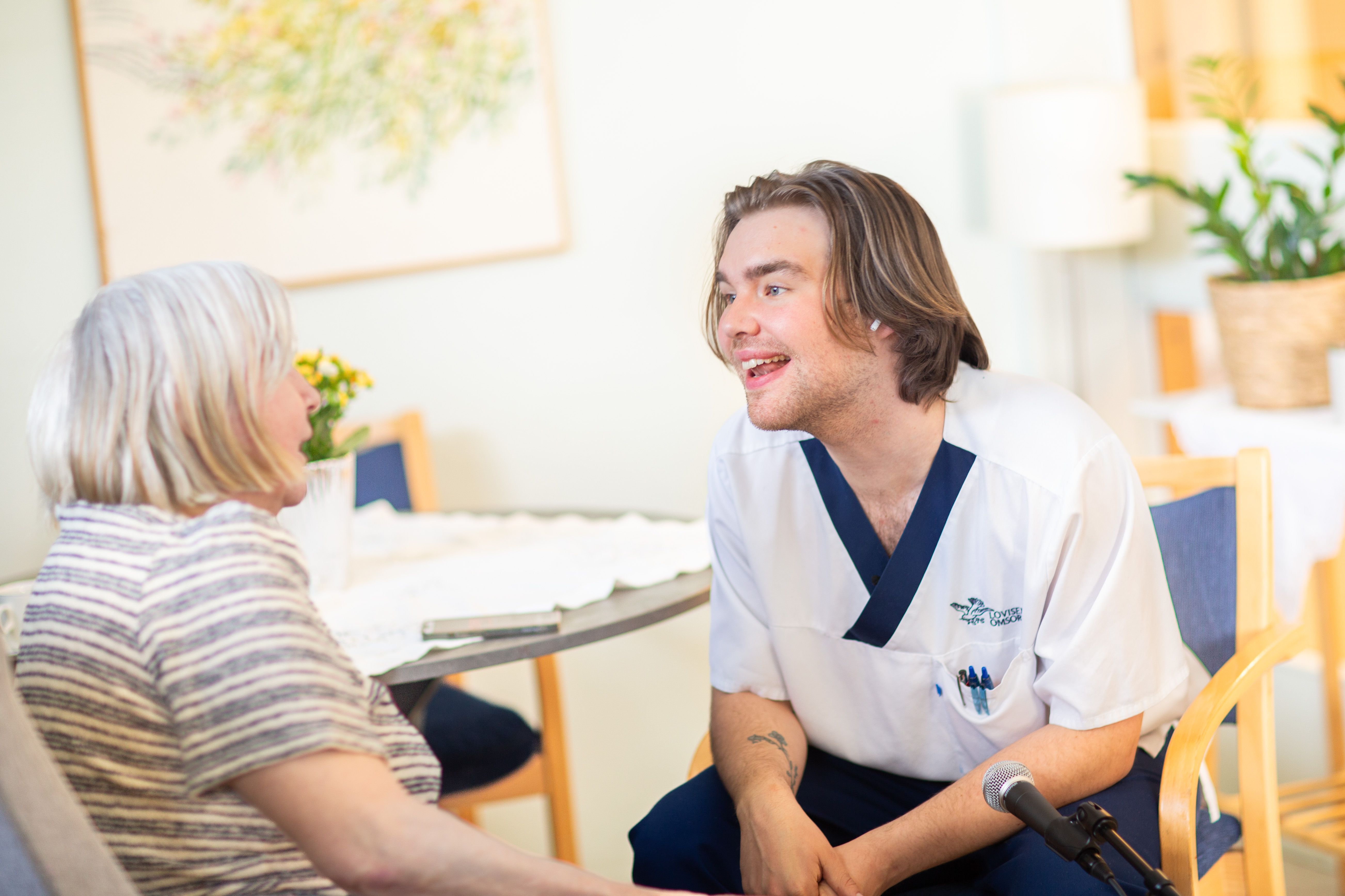 Ansatt synger med beboer på sykehjemmet