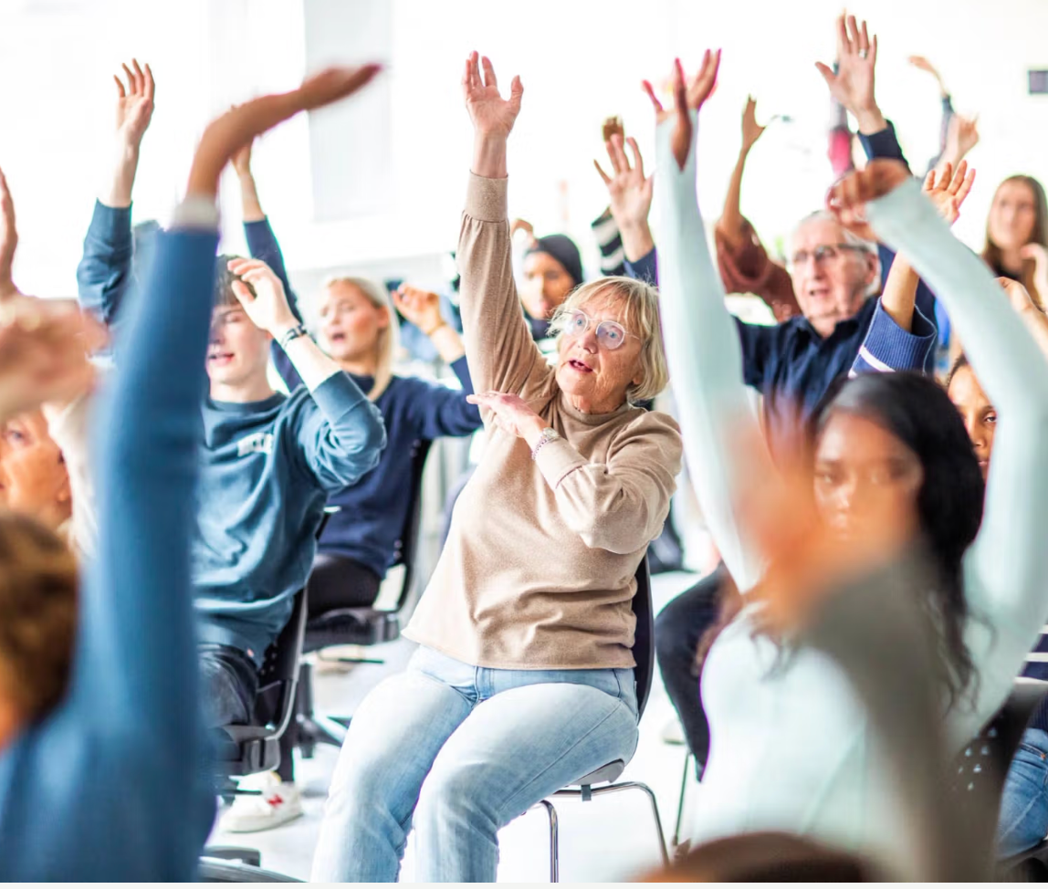 Eldre og ungdom trimmer og synger sammen.
