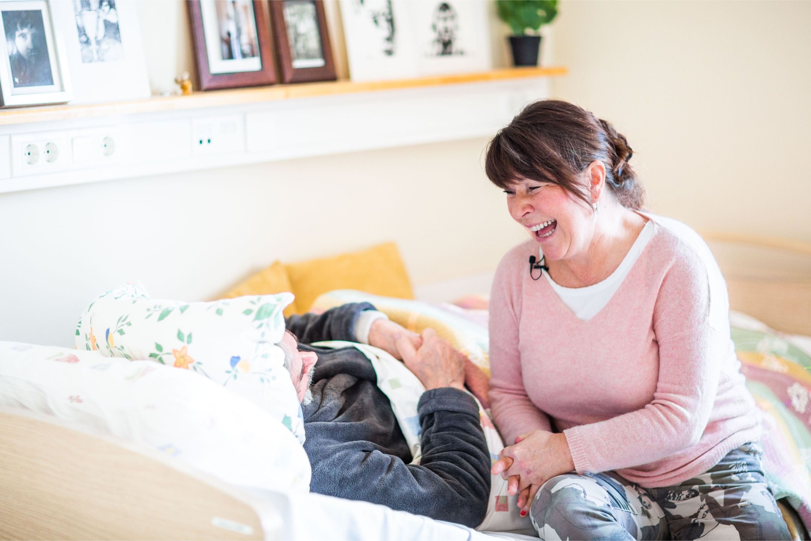 Kvinner synger for sengeliggende beboer på eldreinstitusjon