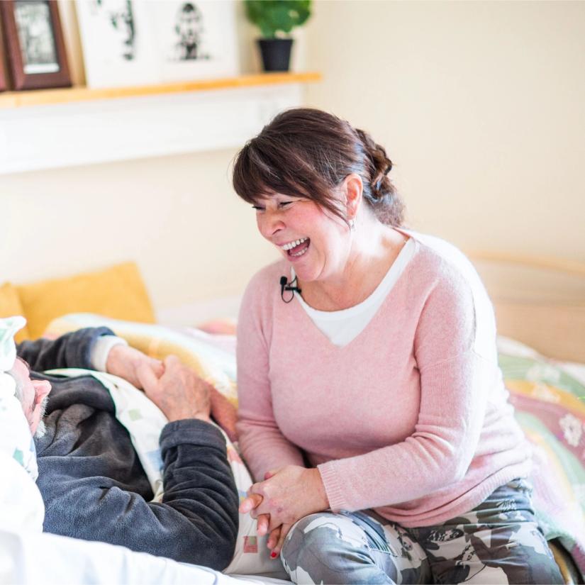 Kvinner synger for sengeliggende beboer på eldreinstitusjon