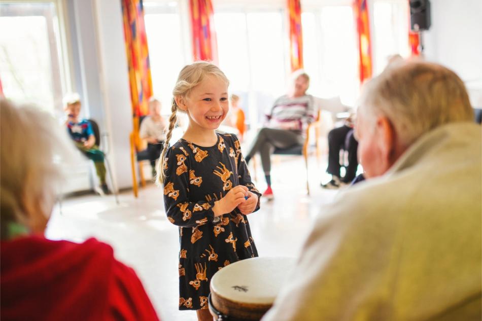 Barn synger sammen med eldre mann i en generasjonssangstund i Skien kommune.