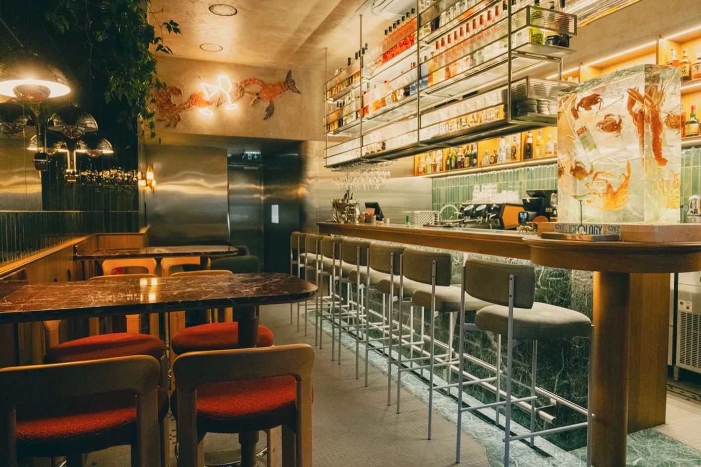 Interior of Pinch Lisbon with marble tables, bar stools and the green-tiled bar