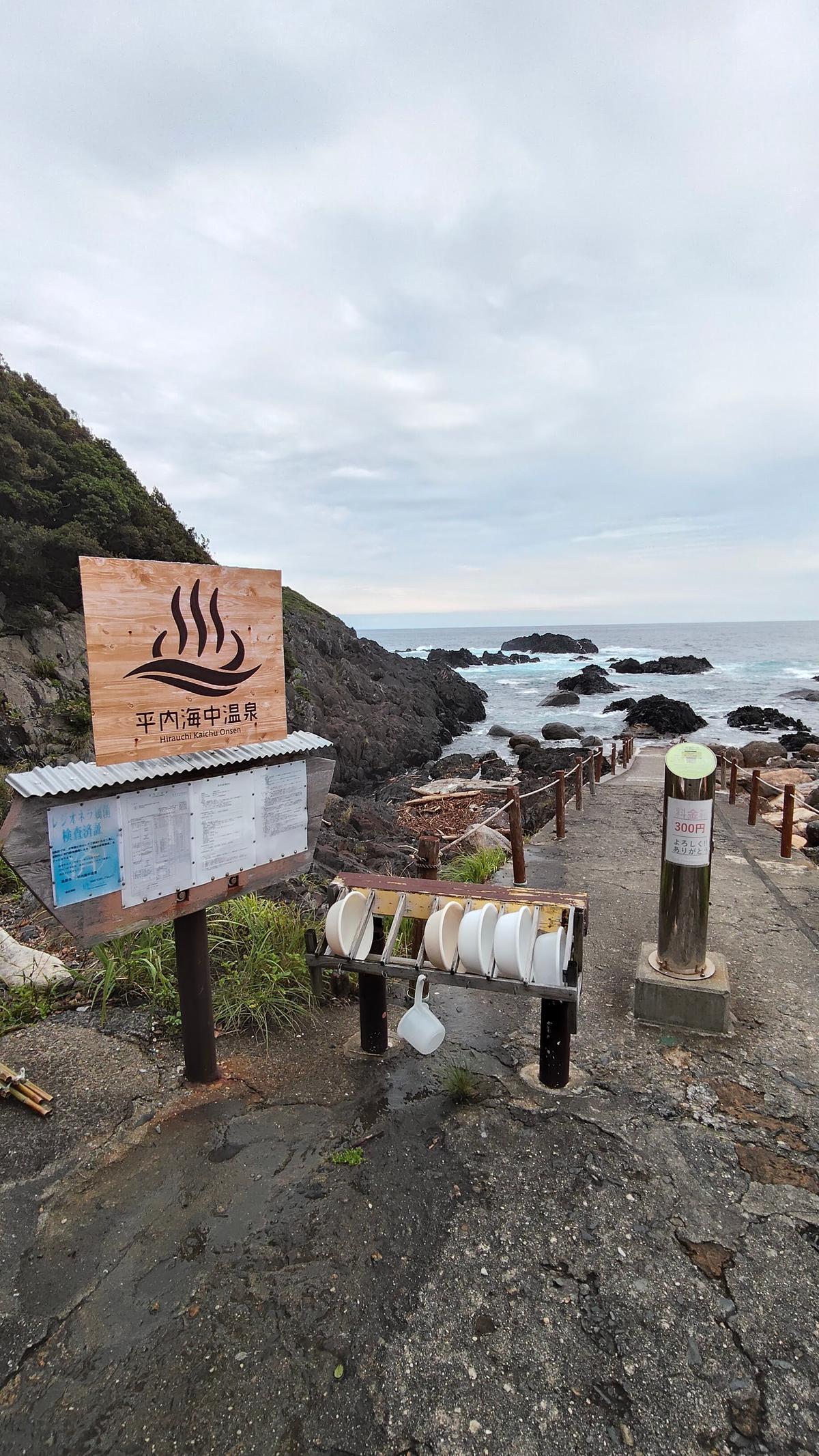 「平内海中温泉」の看板と、目の前に広がる海
