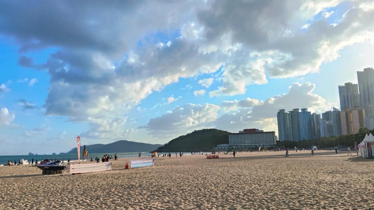 海雲台の砂浜。右手にビル、左手に緑の丘