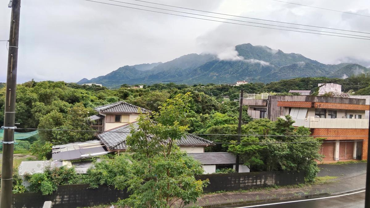 宿の窓から見た、雲をかぶった朝の屋久島の山なみ