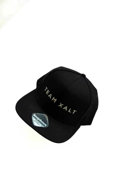 Eine schwarze Snapback-Kappe mit goldener TEAM-XALT-Stickerei